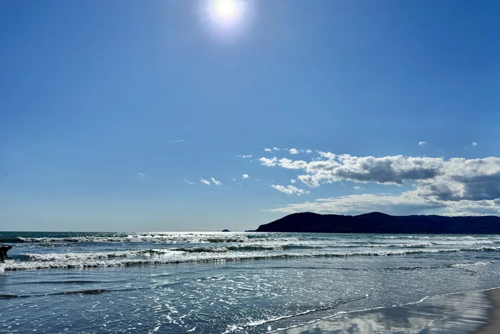 Il Golfo dei Poeti illuminato dalla luce del sole, con le onde che si infrangono sulla costa.