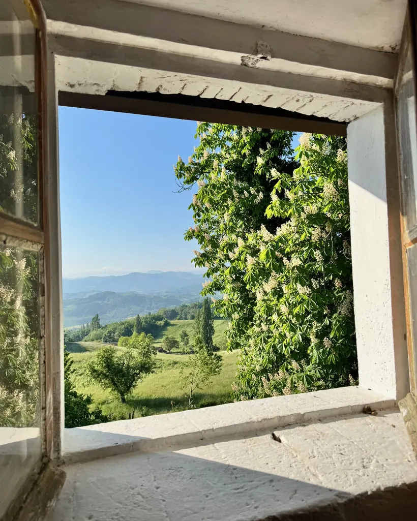 Finestra di Casa Urzano aperta sulla vista delle colline dell'Appennino